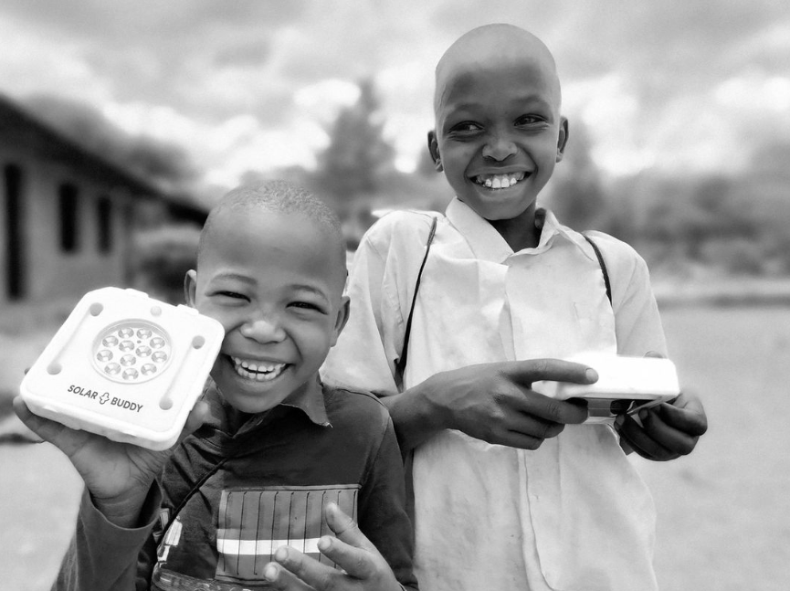 Two children from the solar buddy program smiling at the camera in their town.
