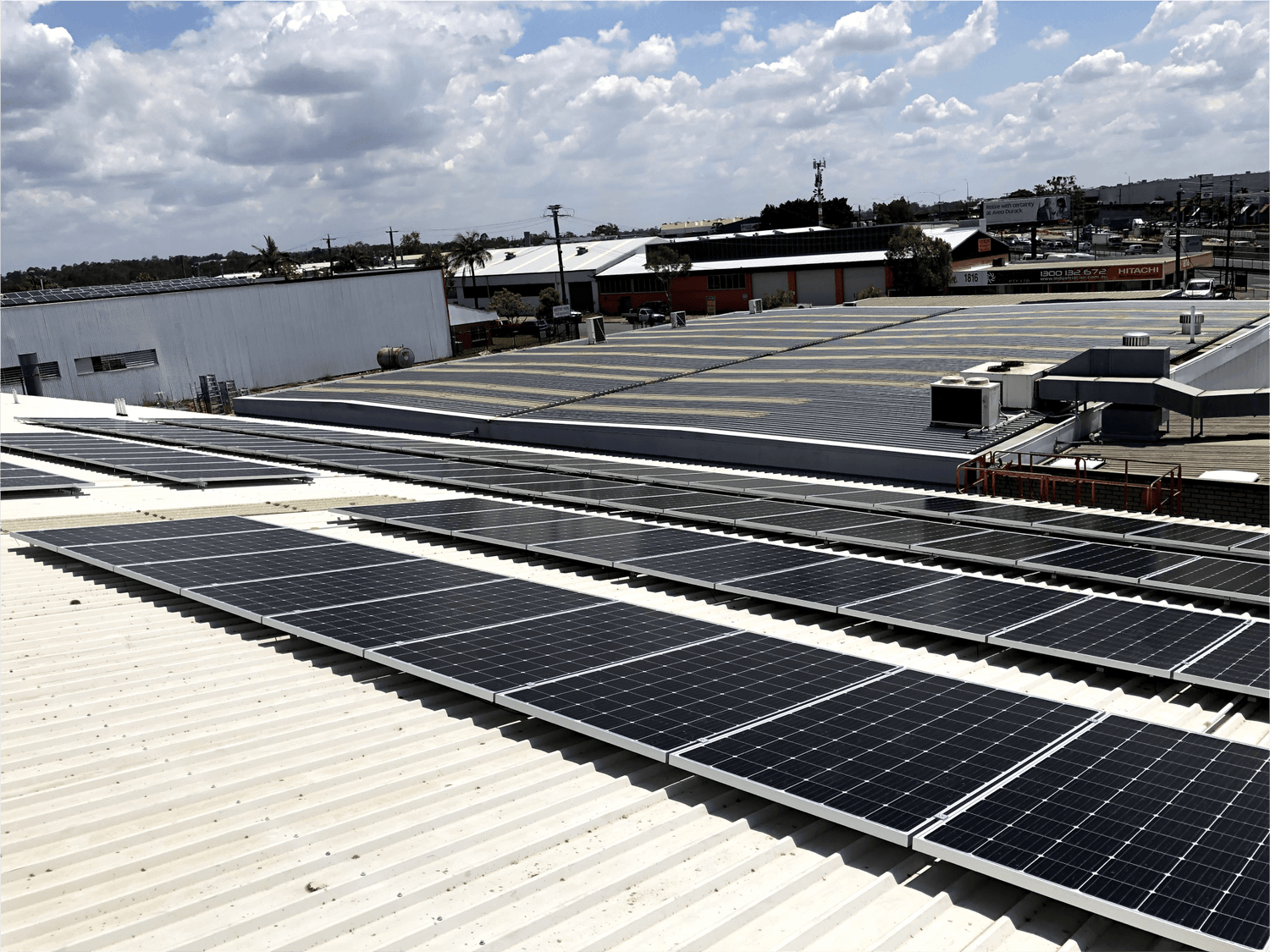 Solar panels installed on a warehouse in Brisbane. There are four rows of 10 panels on a tin roof.
