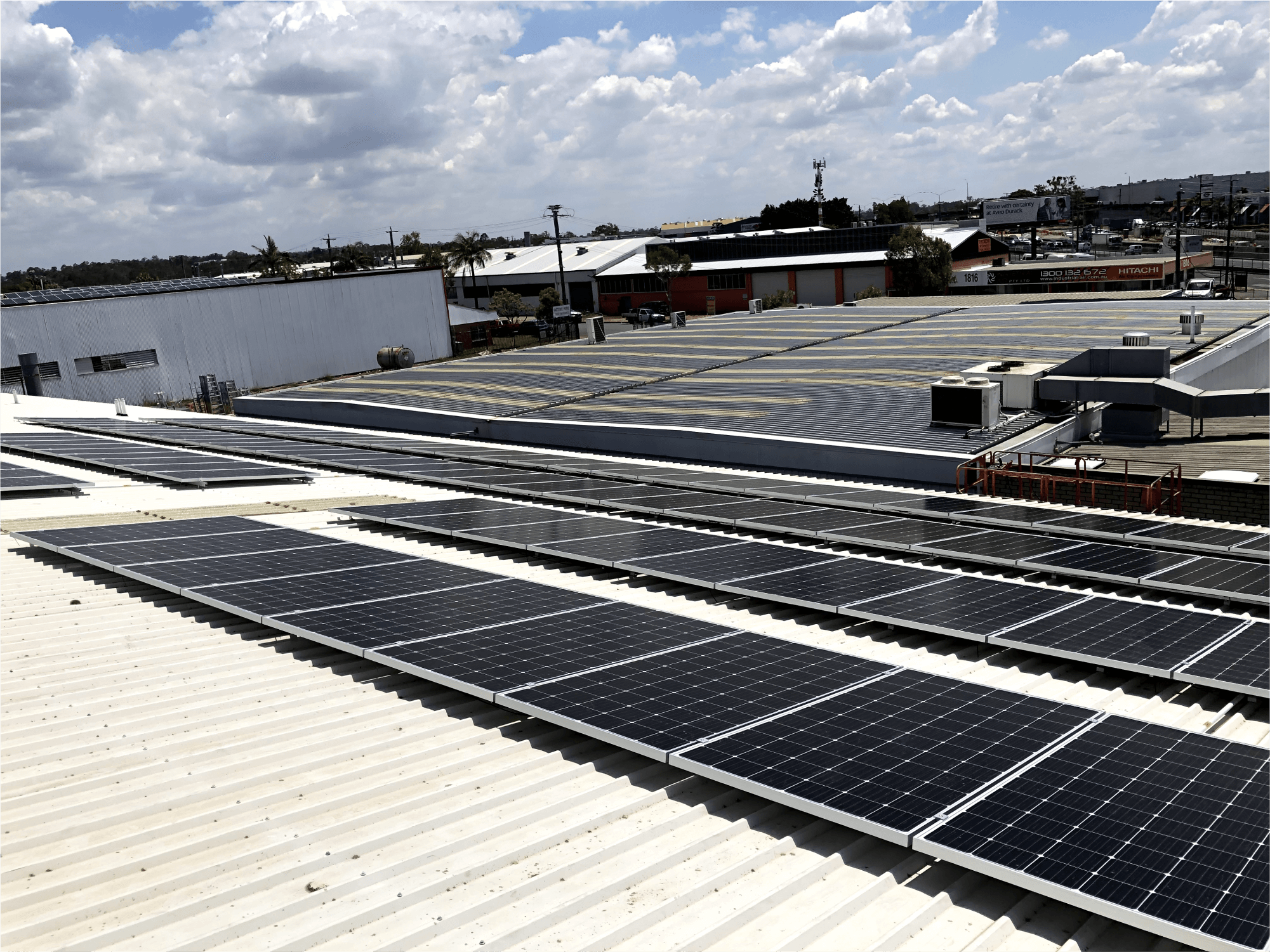 Solar panels installed on a warehouse in Brisbane. There are four rows of 10 panels on a tin roof.