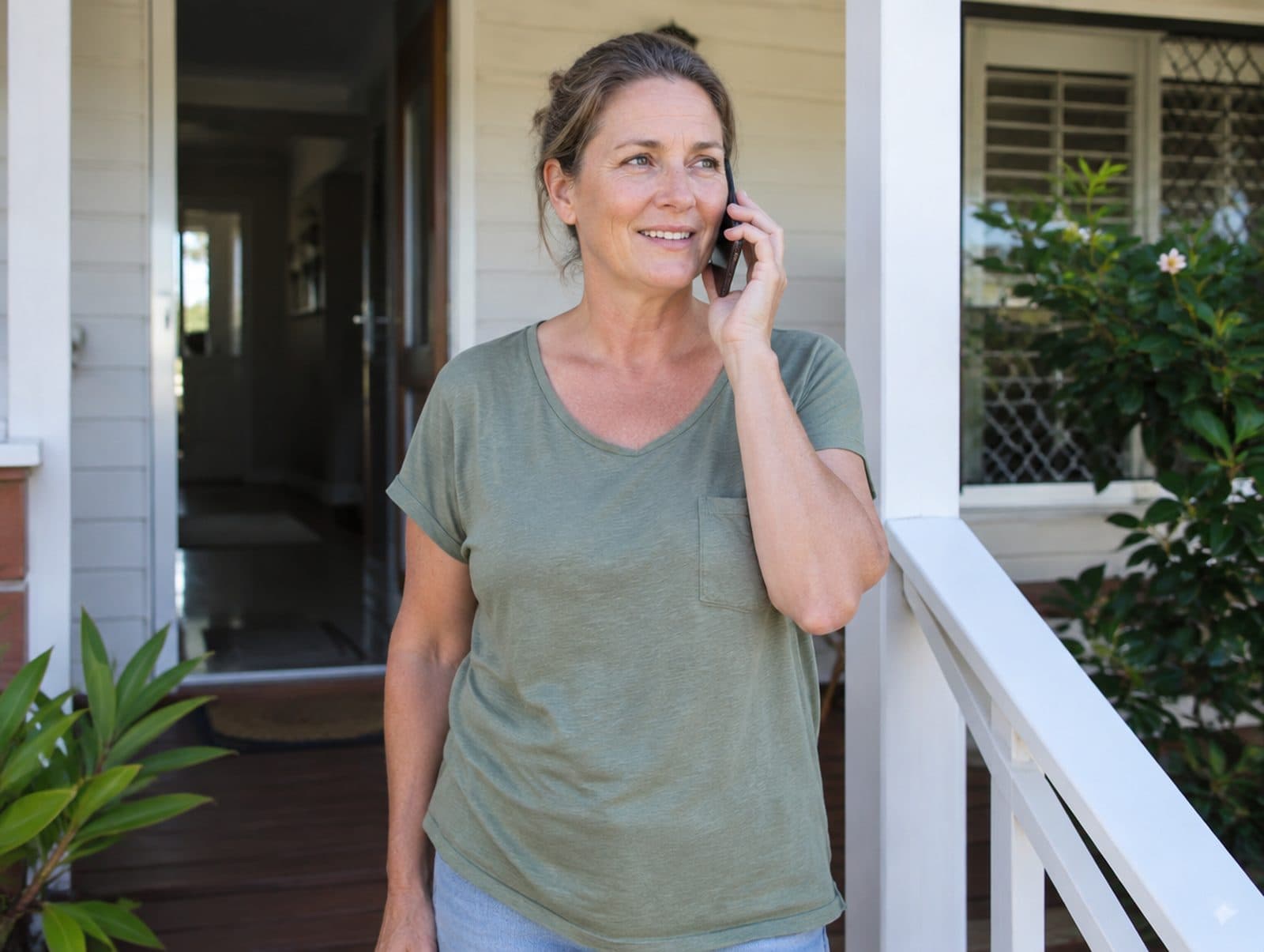 A homeowner on her front step, on the phone about a solar fault