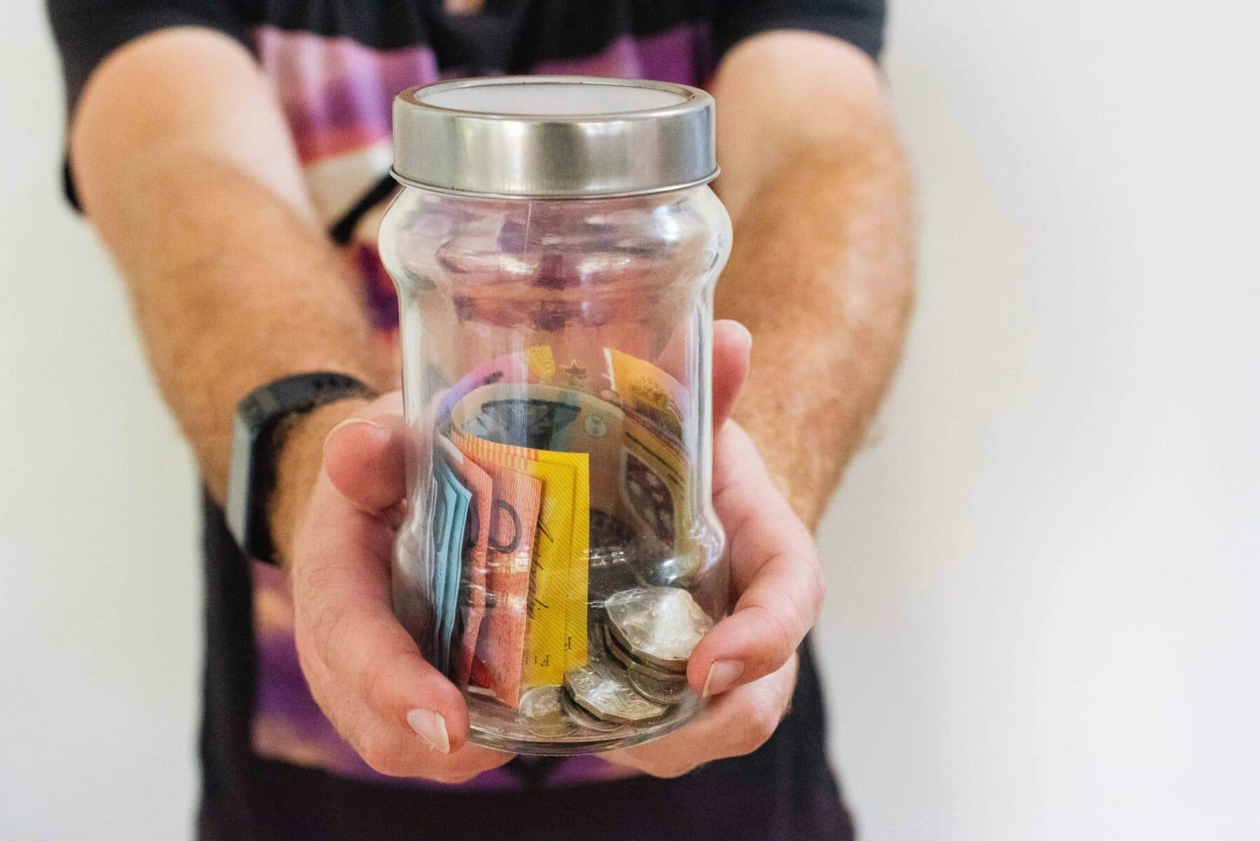 Hands holding a jar of Australian cash savings