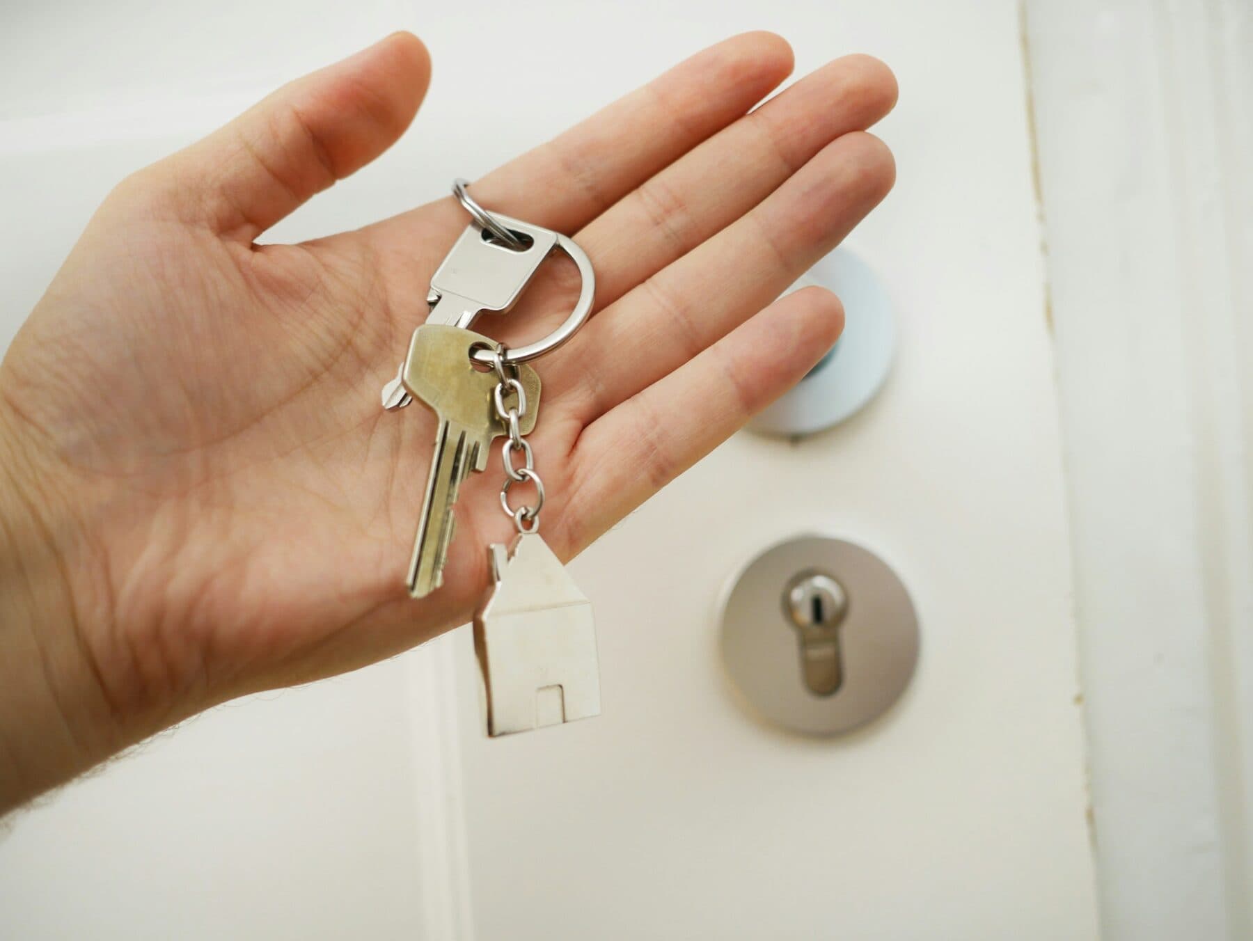 A hand holding a set of house keys