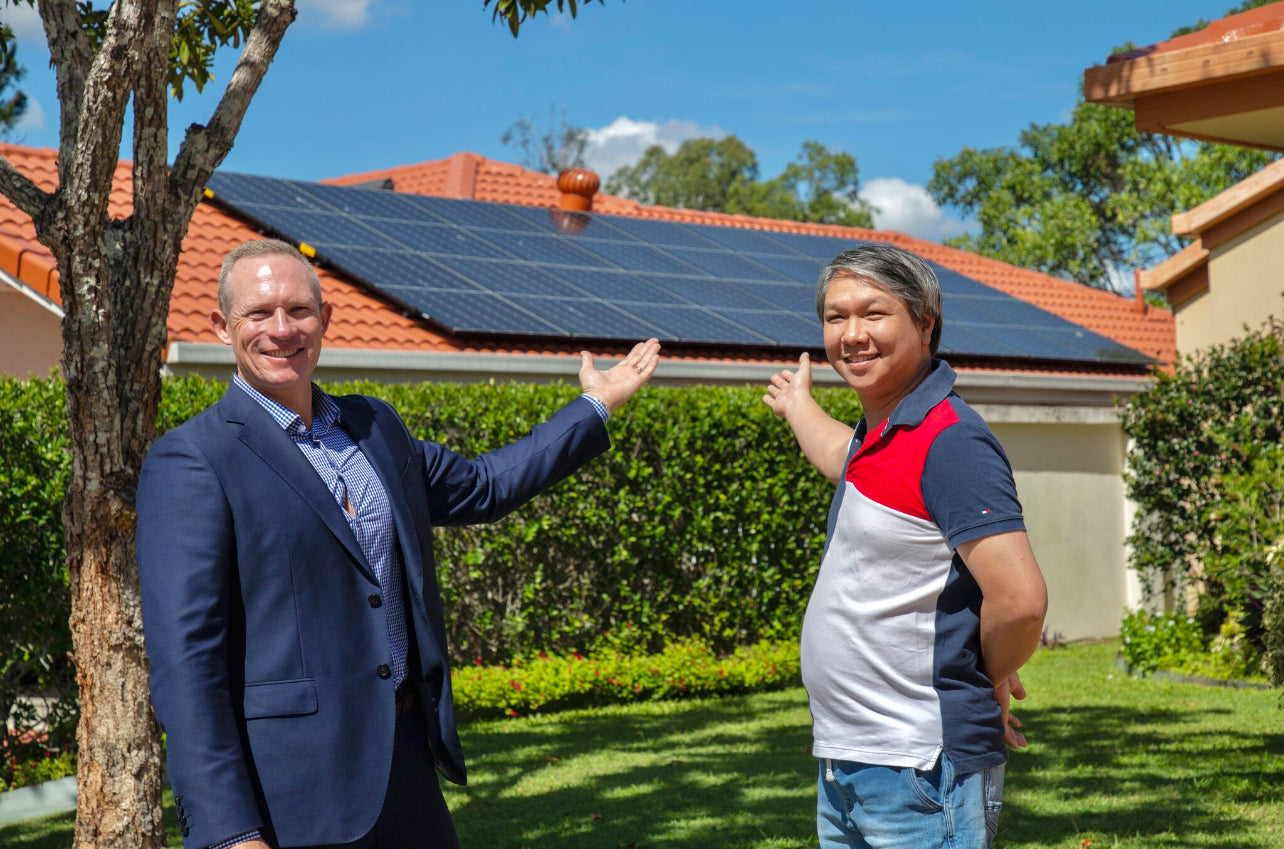 Energy Minister for Queensland, Mick de Brenni, and UV Power solar supplier and installer client David in front of David's home, admiring the solar system installed by UV Power.