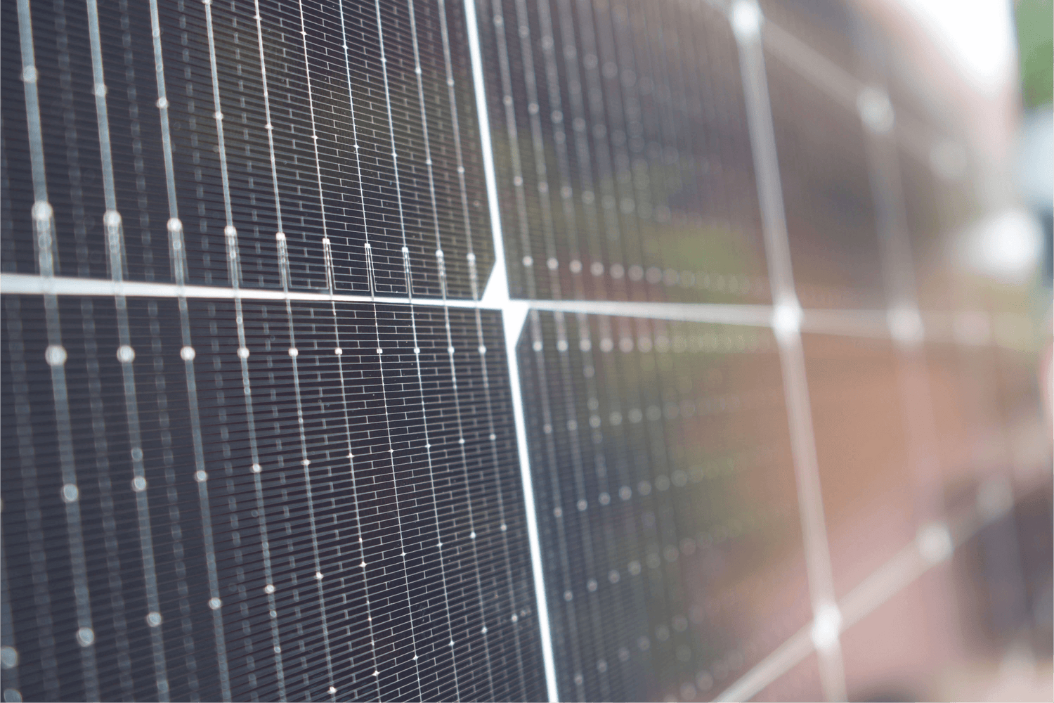 A detailed view of a solar panel, capturing its intricate design and the reflection of sunlight on its surface.