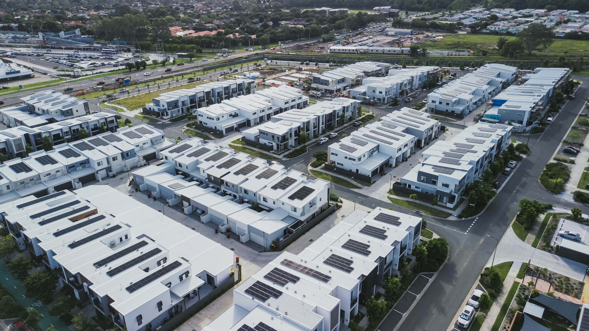 Aerial view of Carseldine Village, a residential development showcasing solar panels, harnessing renewable energy for sustainable living.
